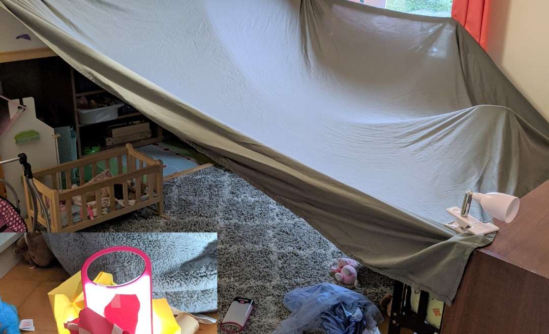 sheet attached to bunkbed and shelf to make a tent: inlay picture- fake campfire made with toilet paper rolls, flashlight, and construction paper