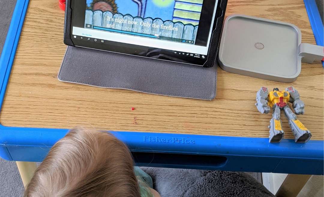 little girl watching tablet with animated story book