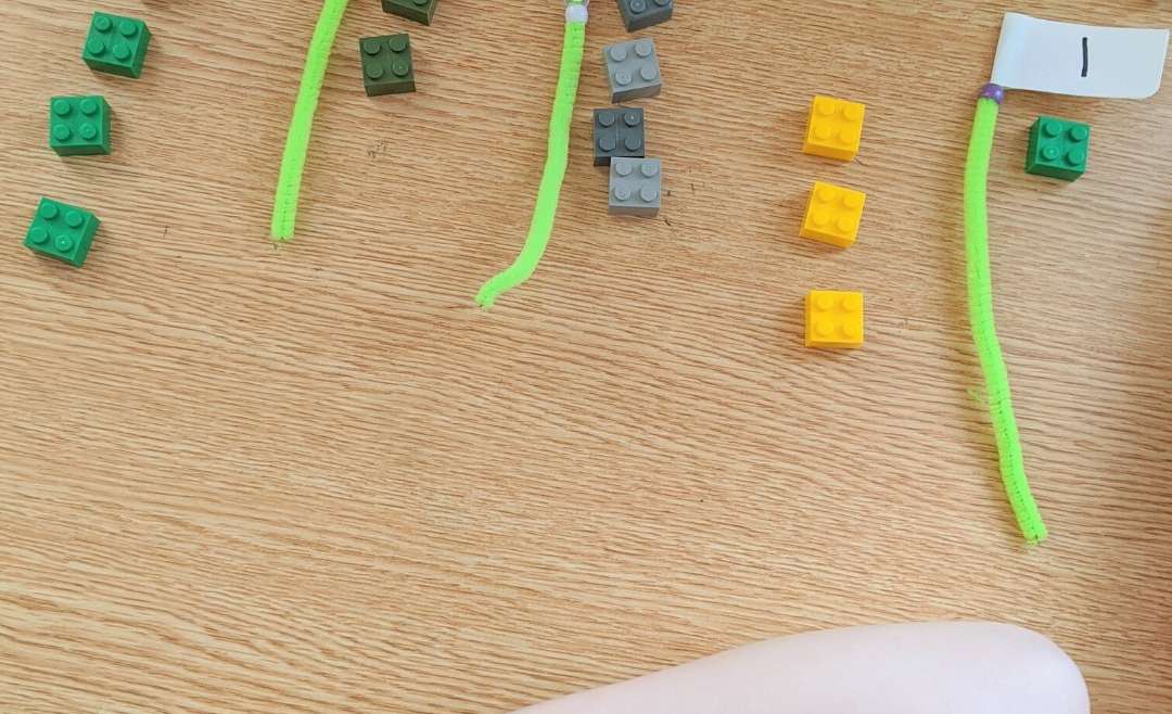 Pipe cleaners with numbers on them and the same amount of legos next to them